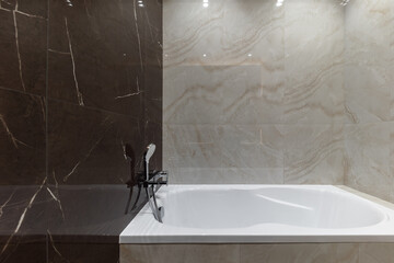 Bath close up. Light beige and brown modern bathroom interior with bath and shower and white...