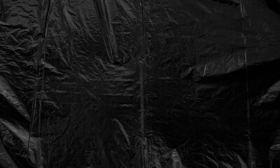 black plastic bag texture, wrap texture on a black background wallpaper, wrinkled plastic pattern...