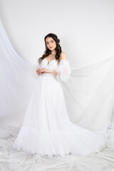 Fototapeta premium Beautiful sexy woman brunette in fashion long dress for party wedding. Bride natural model with natural makeup style for celebrity white background