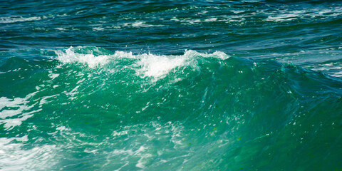 Obraz premium green wave background in natural day light. blurred water and foam texture