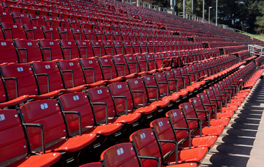 Many rows of red and black numbered seats in an outdoor stadium