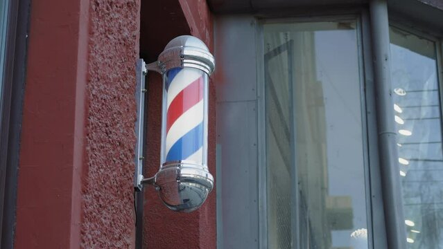 The movement of the Rotating Barbershop Pole on the street facade of the building. Attention-grabbing street advertising.