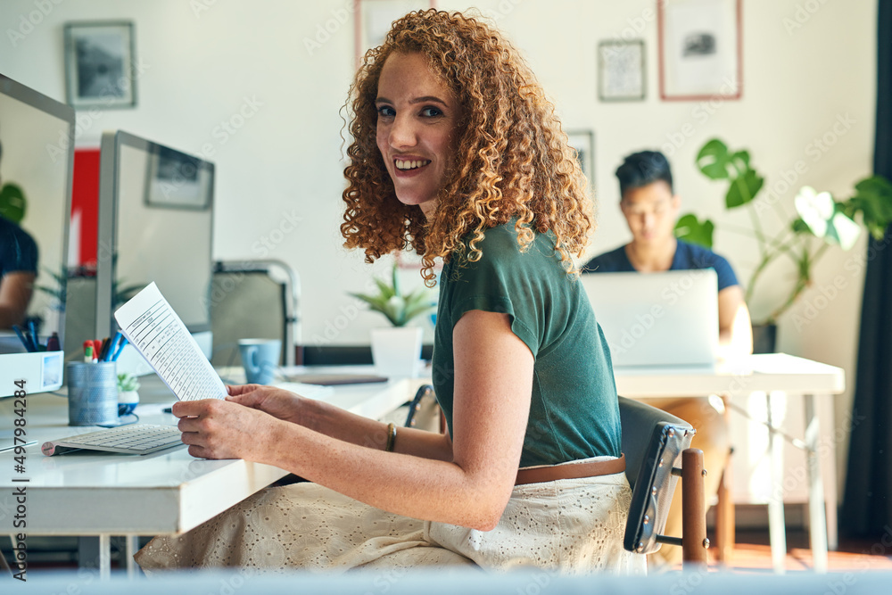 Aufkleber getting my paperwork in order. cropped portrait of an attractive young female designer reading over 