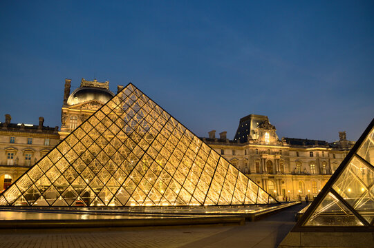 Paris, France - November 18, 2021: View of the Musee du Louvre with the Pyramid at night. This is one of the most popular travel destinations of France and a central landmark of Paris.