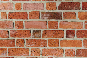 Textured red brick wall background or backdrop, rectangular red terracotta bricks laid out as...