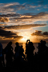 Silhuetas das pessoas felizes em Fernando de Noronha acompanhando o pôr-do-sol