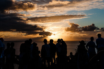 Fototapeta na wymiar Silhuetas das pessoas felizes em Fernando de Noronha acompanhando o pôr-do-sol