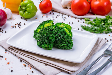 Boiled Broccoli on a white plate on white table