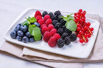 plate with fresh berries, strawberry, blackcurrant, redcurrant, black berries