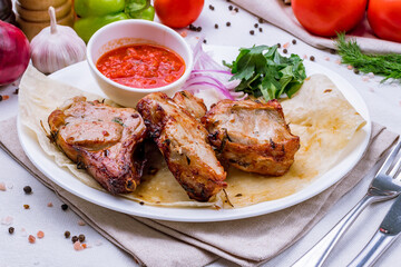 Fried pork loin with sauce and red onion on white plate
