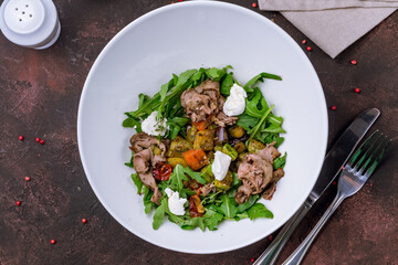 Salad with roast beef and poached egg on white plate top view