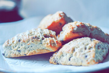 blueberry scones served in a white plate on a wooden table, pictured in modern tones.