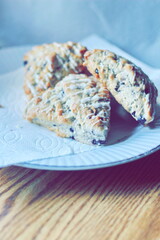 blueberry scones served in a white plate on a wooden table, pictured in modern tones.