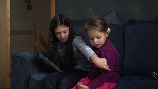 authentic 3 little preschool toddler minor children kids siblings watch cartoon playing games online chating on smartphone device laptop tablet together at home indoors. Family, childhood, friendship