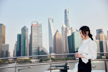 Asian business woman with urban skyline in Shanghai, China.