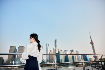 Asian business woman with urban skyline in Shanghai, China. © Dusan