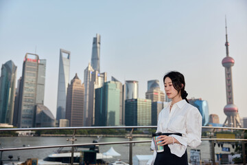 Asian business woman with urban skyline in Shanghai, China.