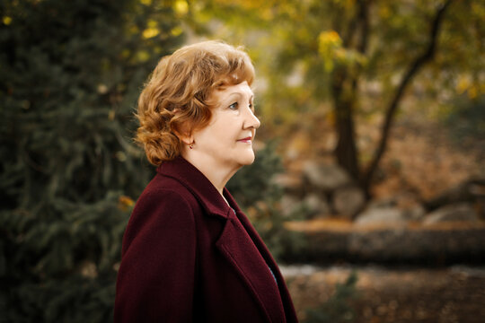 Profile Of A Caucasian Mature Woman In A Coat Walking Outdoor