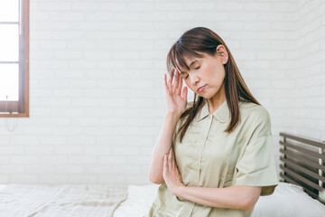 体調が悪いミドル世代の女性（頭痛・体調不良）
