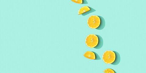 Citrus lemon fruit as creative background, slices of citrus with hard shadows at sunlight on pastel mint background with copy space. Healthy fruits food concept. Flat lay, top view