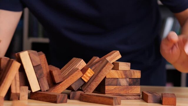 Building wood blocks tower on table, falling down on table, high risk assessment. Risk assessment and strategy concept.