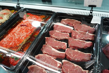 Almaty, Kazakhstan - 12.23.2021 : Smoked semi-finished products in the refrigerator in a large hypermarket.