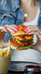Female hands holding juicy burger in hands
