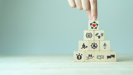 Employee engagement and team motivation. Productive people, inspiration. Common goals of the company and employees for sustainability. Putting  wooden cubes engagement icon with the ways of building.