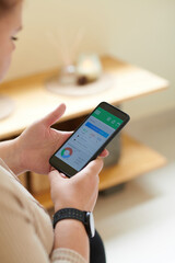 Woman checking food diary and micronutrient chart in health application on smartphone
