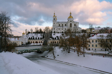 Obraz premium View of the Assumption Mountain, the Holy Spirit Monastery and the Holy Assumption Cathedral on the bank of the Vitba river on a sunny winter day, Vitebsk, Belarus