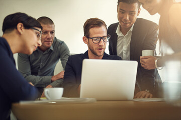 Getting some advice from his coworkers. Shot of a group of coworkers discussing something on a laptop during a meeting.