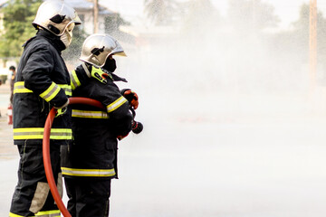 Firefighters using Twirl water fog type fire extinguisher to fighting with the fire flame from oil...