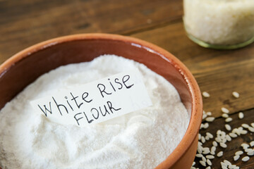 Rice flour. Rice flour on a wooden background. Whole rice. Side view.