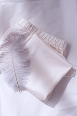 Women's pajamas on a light background with a feather