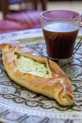 Baked bread filled with cheese and served with coffee 
