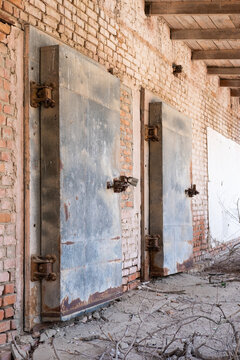 Two big old barn door with concrete wall background texture and steel barrier block. Old big orange color gate with concrete wall texture surface and iron barrier stand