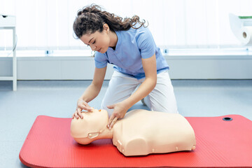 woman practicing cpr technique on dummy during first aid training. First Aid Training - Cardiopulmonary resuscitation. First aid course on cpr dummy.