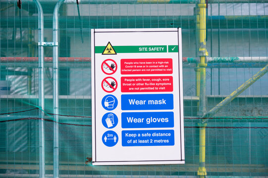 Construction site health and safety message rules sign board signage on fence boundary
