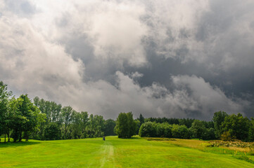 Wilde Wolkenstimmung mit aufziehendem Gewitter über dem Golfplatz an einem Sommertag