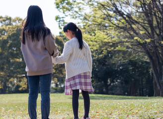 春の公園で遊んでいる子供姉妹の姿