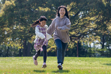Fototapeta premium 春の公園で遊んでいる子供姉妹の姿