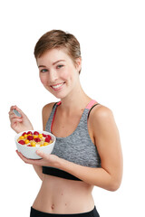 Its not about eating less, its about eating right. Studio portrait of a fit young woman eating a bowl of fruit and granola against a white background.