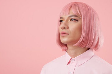 Portrait of young man with glam rhinestone makeup wearing pink bob wig