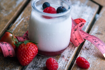 Two strawberry yogurt milk shakes with fresh strawberries on a table next to ingredients