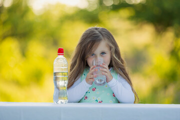 girl drinking water on the background of nature
