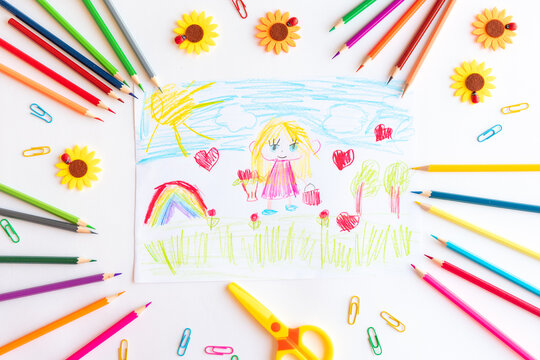 A child draws a postcard for mother's day. Beautiful landscape with mom drawn with pencils.