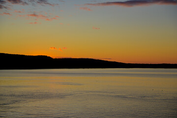 Sunset over mountains viewed from docked cruise ship as passengers enjoy the wonder of nature.