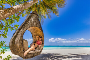 Young beautiful girl in swimsuit blonde hair relaxing in hammock luxury tropical beach amazing landscape. Outdoors vacation lifestyle portrait stunning young woman enjoying swing on tropical palm tree