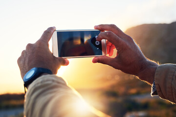 I cant wait to show my friends these photos. Shot of a hiker on top of a mountain capturing a...