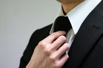 葬儀の服装に着替える日本人男性